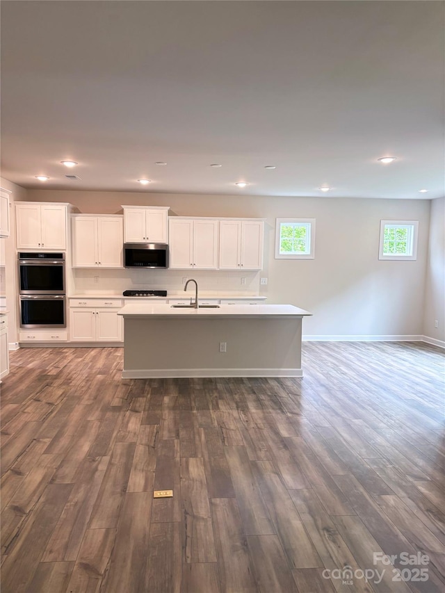 7001 New Town Rd, Waxhaw, NC 28173 - kitchen featuring stainless steel appliances, a sink, an island with sink, dark wood finished floors, and recessed lighting