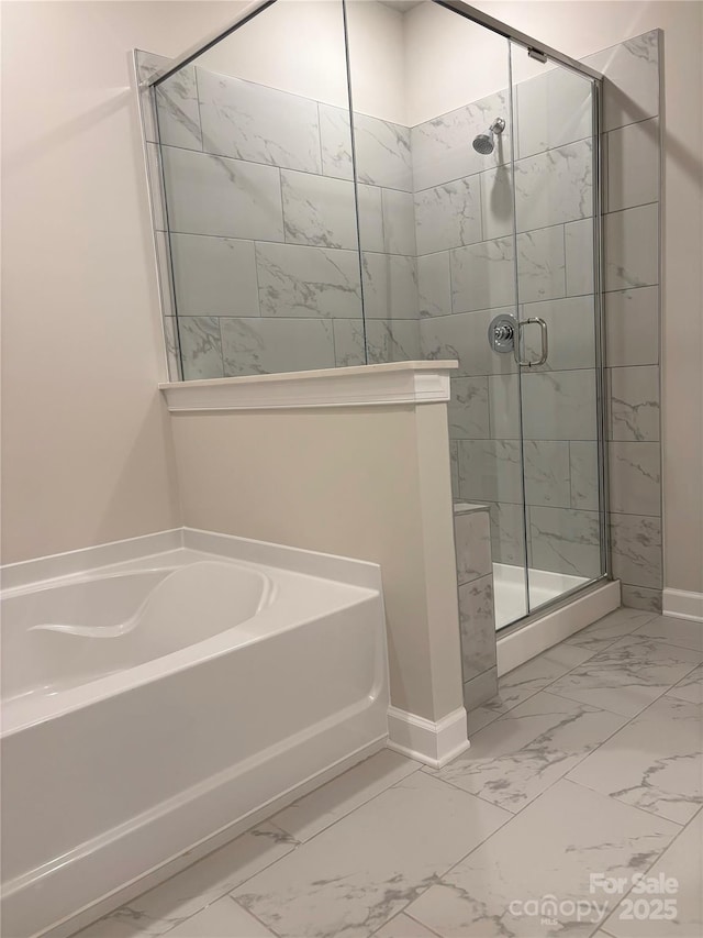 7001 New Town Rd, Waxhaw, NC 28173 - bathroom featuring marble look tile flooring, a garden tub, a stall shower, and baseboards
