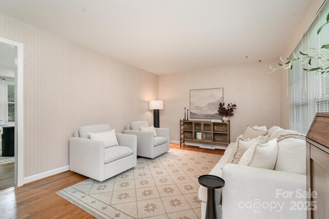 5329 Glenbrier Dr, Charlotte, NC 28212 - living room with light wood-style floors, wallpapered walls, baseboards, and healthy amount of natural light