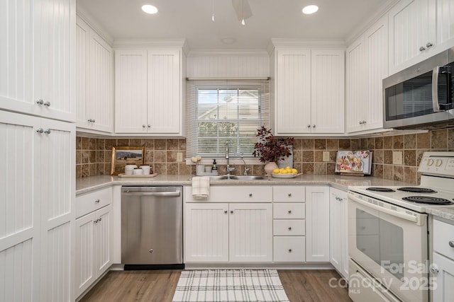 5329 Glenbrier Dr, Charlotte, NC 28212 - kitchen with appliances with stainless steel finishes, a sink, white cabinetry, backsplash, and recessed lighting