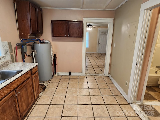 kitchen featuring electric panel, light tile patterned floors, light countertops, gas water heater, and ceiling fan