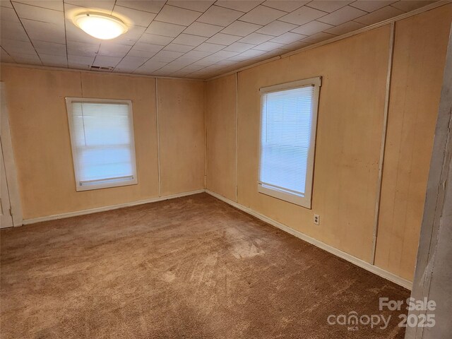 unfurnished room featuring carpet and visible vents