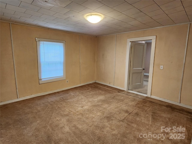 empty room featuring carpet flooring and baseboards