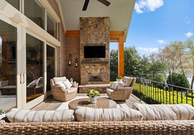 view of patio with a ceiling fan and an outdoor living space with a fireplace