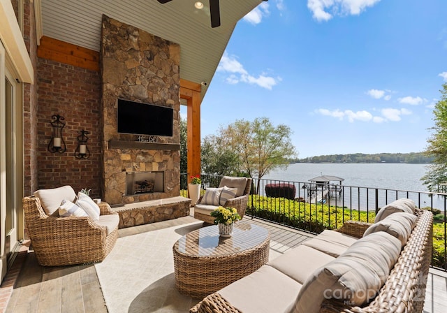 view of patio with ceiling fan and an outdoor living space with a fireplace
