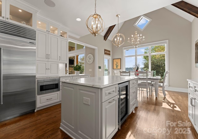 kitchen with built in refrigerator, a chandelier, white cabinetry, high vaulted ceiling, and wine cooler