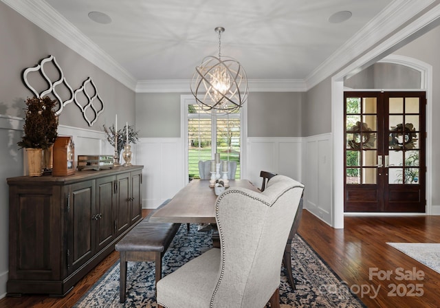 dining space with french doors, wainscoting, a chandelier, and dark wood-type flooring