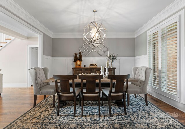 dining space with an inviting chandelier, stairway, wood finished floors, and wainscoting
