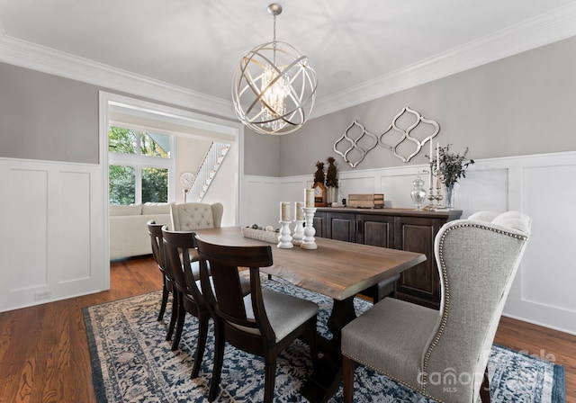 dining room featuring a decorative wall, a chandelier, ornamental molding, a wainscoted wall, and dark wood-style floors