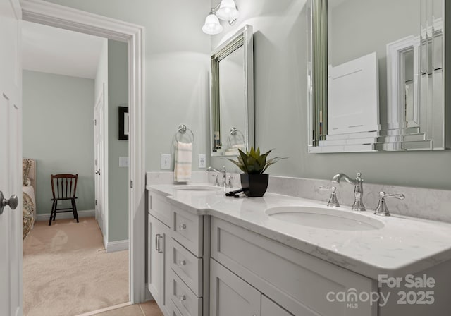 full bath featuring double vanity, a sink, and baseboards