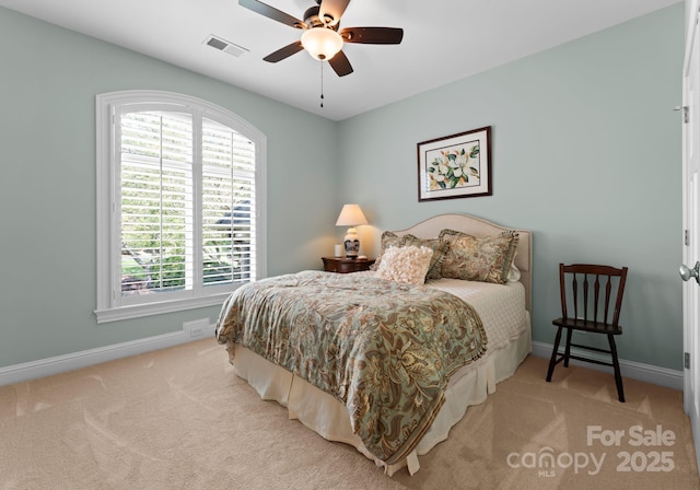 carpeted bedroom featuring baseboards, visible vents, a ceiling fan, and multiple windows