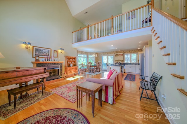 161 Hamburg Mountain Rd, Weaverville, NC 28787 - living room featuring a high ceiling, light wood-style floors, a fireplace, and stairs
