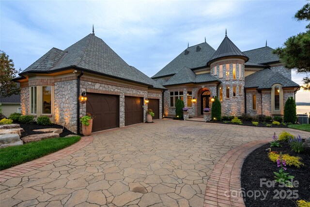 325 Ivy Arbor Cir, Rock Hill, SC 29732 - french country home with stone siding, a garage, decorative driveway, and a high end roof