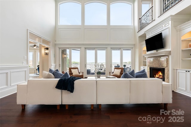 325 Ivy Arbor Cir, Rock Hill, SC 29732 - living area with a fireplace, built in shelves, a high ceiling, a decorative wall, and a wainscoted wall