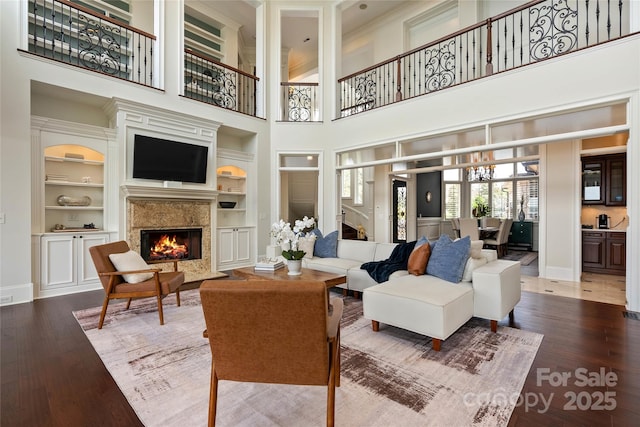 325 Ivy Arbor Cir, Rock Hill, SC 29732 - living room featuring built in shelves, baseboards, a fireplace, wood finished floors, and a high ceiling
