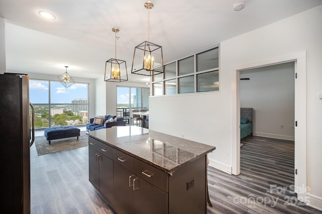 333 W Trade St Unit 1802, Charlotte, NC 28202 - kitchen with a center island, dark wood-type flooring, stainless steel fridge, and an inviting chandelier
