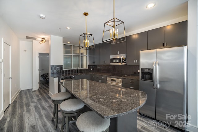 333 W Trade St Unit 1802, Charlotte, NC 28202 - kitchen featuring a kitchen breakfast bar, dark wood-type flooring, backsplash, a kitchen island, and appliances with stainless steel finishes