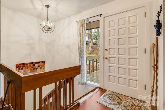 foyer featuring a notable chandelier and wood finished floors