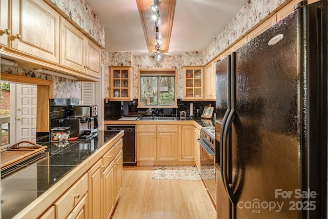 kitchen featuring light wood-style flooring, wallpapered walls, glass insert cabinets, black appliances, and light brown cabinetry
