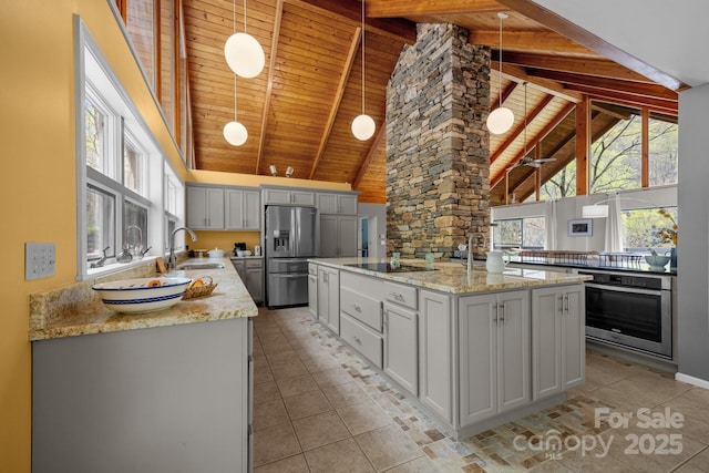 kitchen with stainless steel appliances, wooden ceiling, beam ceiling, a center island with sink, and high vaulted ceiling