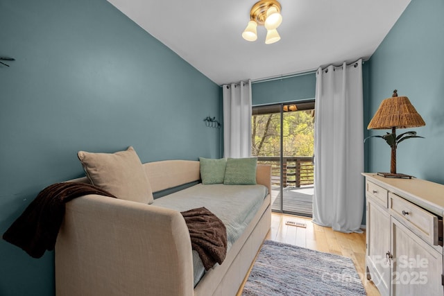 bedroom with light wood-type flooring, visible vents, and access to outside