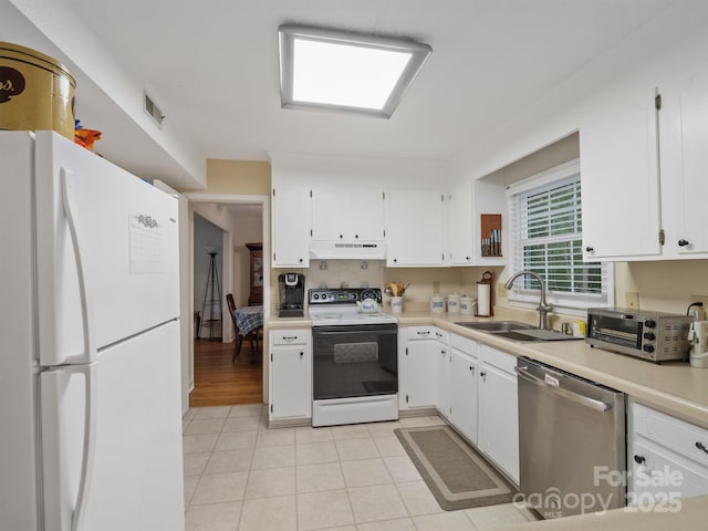 2248 Lawton Bluff Rd, Charlotte, NC 28226 - kitchen with freestanding refrigerator, electric stove, stainless steel dishwasher, under cabinet range hood, and white cabinetry
