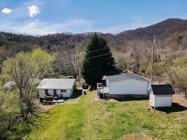 aerial view featuring a wooded view and a mountain view