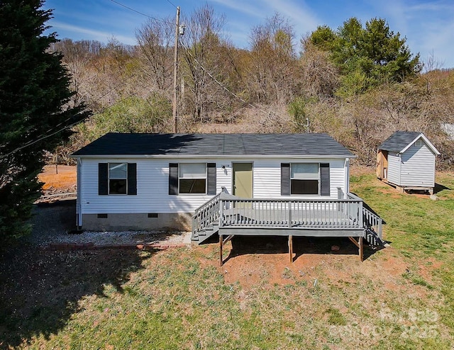 view of front of house with an outdoor structure, a wooden deck, crawl space, a storage unit, and a front yard