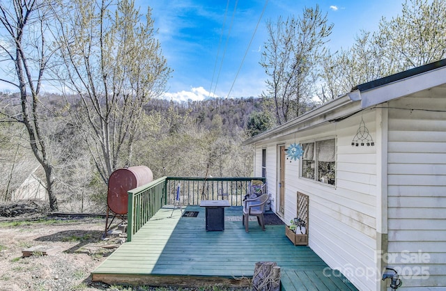 wooden deck with a forest view