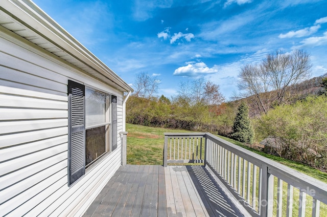 wooden terrace featuring a lawn