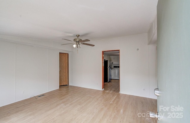 unfurnished room with visible vents, ceiling fan, and wood finished floors