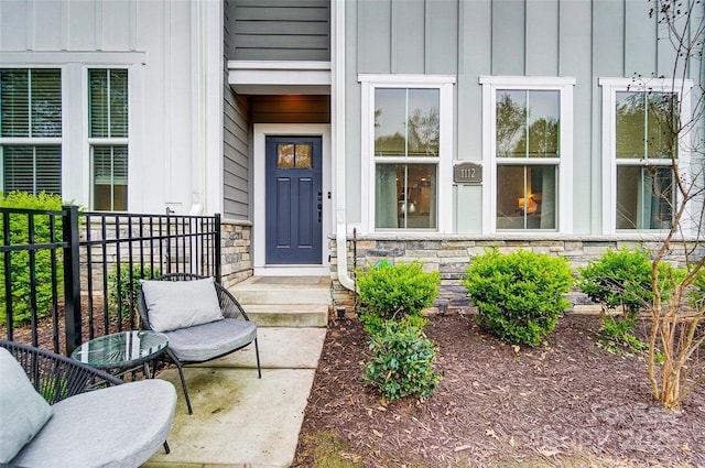 entrance to property featuring stone siding and board and batten siding
