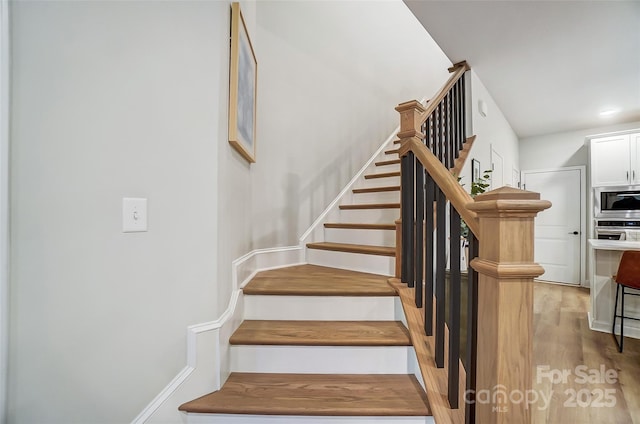 stairs featuring wood finished floors