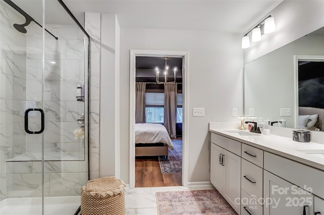 ensuite bathroom featuring a sink, a marble finish shower, ensuite bathroom, marble finish floor, and double vanity