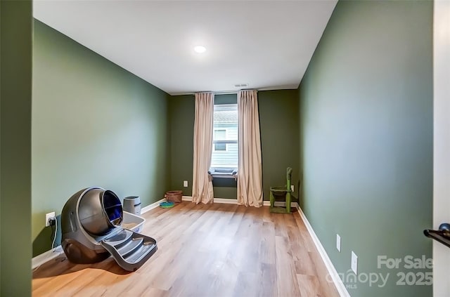 interior space with baseboards, visible vents, and wood finished floors