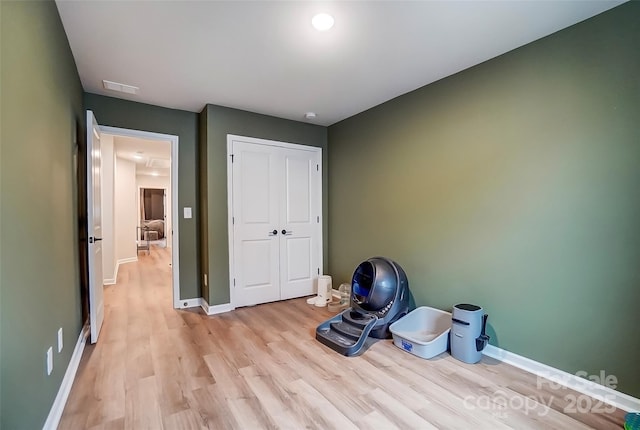 interior space featuring light wood-style flooring, a closet, baseboards, and visible vents