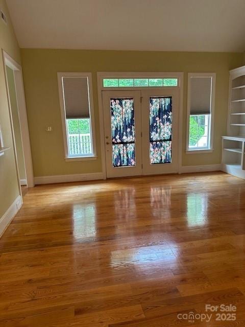 interior space featuring baseboards, a wealth of natural light, and light wood-style flooring