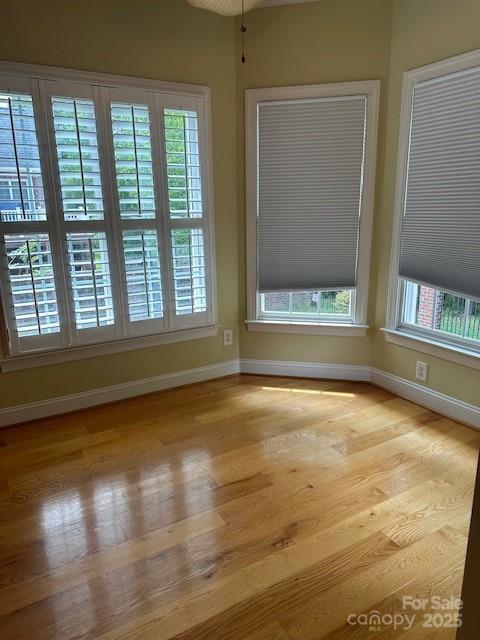 spare room featuring wood finished floors and baseboards