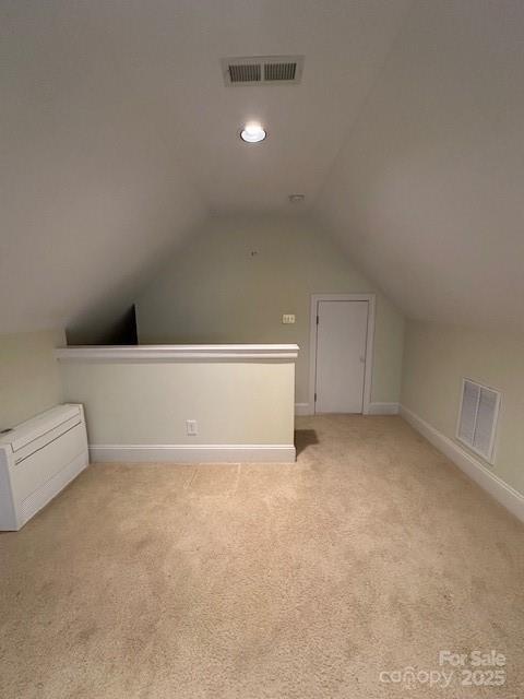 bonus room featuring baseboards, visible vents, light carpet, and lofted ceiling