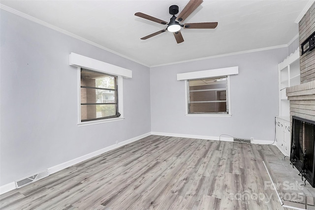 unfurnished living room featuring a ceiling fan, wood finished floors, a fireplace, and visible vents