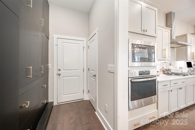 2332 Paddlers Cove Dr, Lake Wylie, SC 29710 - kitchen featuring dark wood-style flooring, light countertops, white cabinetry, wall chimney exhaust hood, and stainless steel appliances