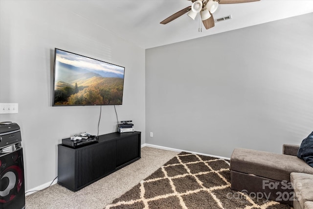 carpeted living area with visible vents, baseboards, and ceiling fan