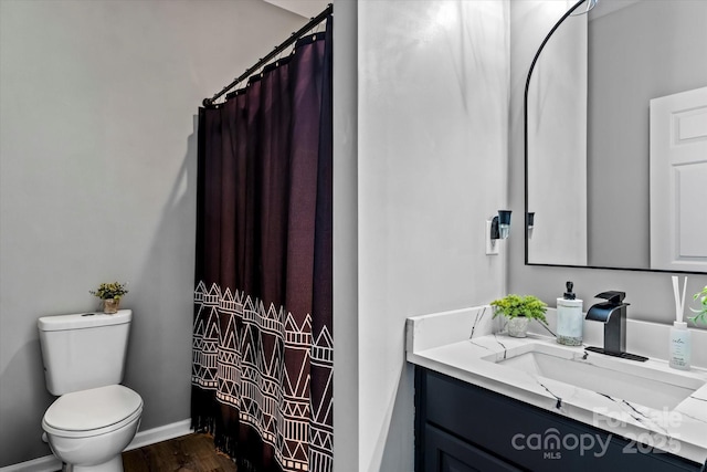 bathroom featuring baseboards, a shower with shower curtain, toilet, vanity, and wood finished floors
