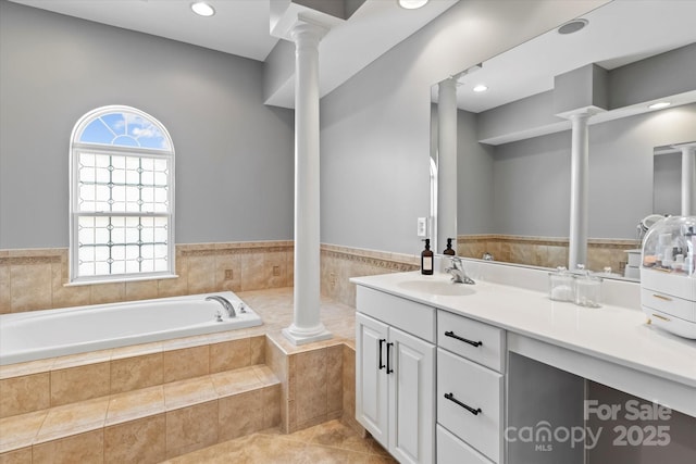 full bathroom featuring vanity, a bath, and ornate columns