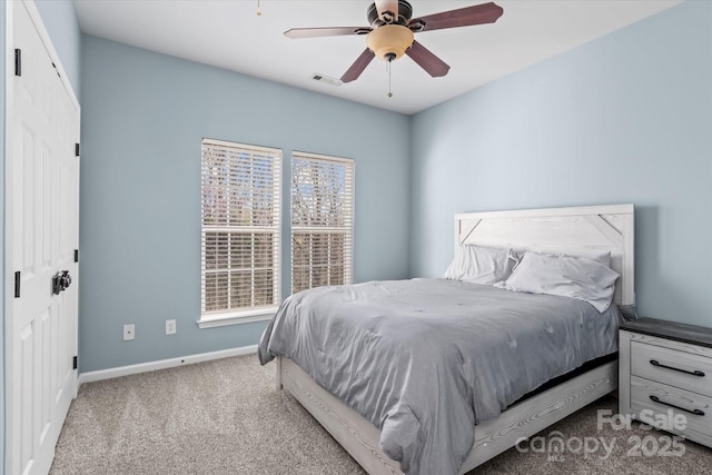 carpeted bedroom with a ceiling fan, baseboards, multiple windows, and visible vents