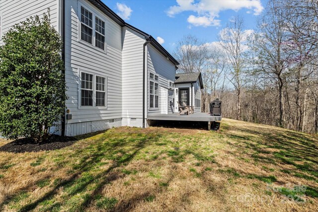 back of house with a yard, a wooden deck, and crawl space