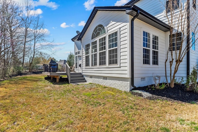 view of side of property with a yard, crawl space, and a wooden deck