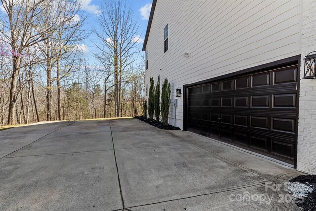 view of side of property with a garage and concrete driveway