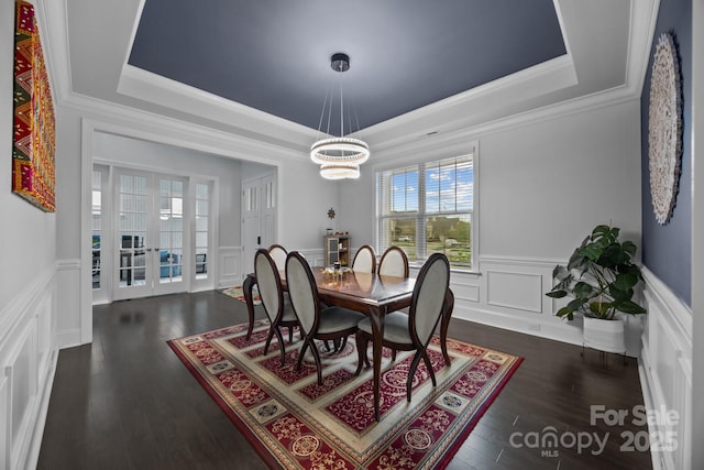 10904 Kilkenny Dr, Matthews, NC 28105 - dining area featuring a raised ceiling, a decorative wall, ornamental molding, a chandelier, and wainscoting