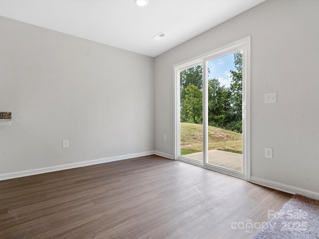 unfurnished room with baseboards and wood finished floors
